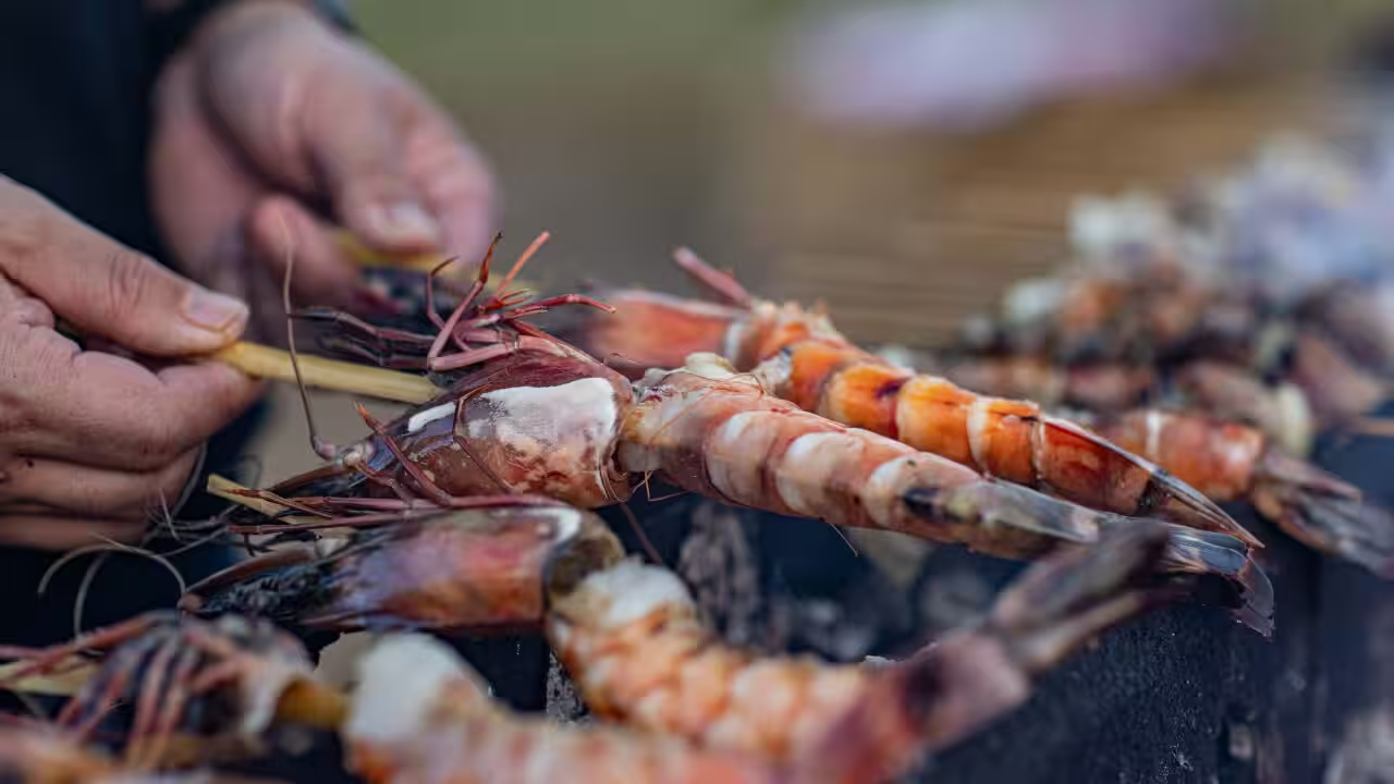 Tiger prawns cooking over the charcoal grill